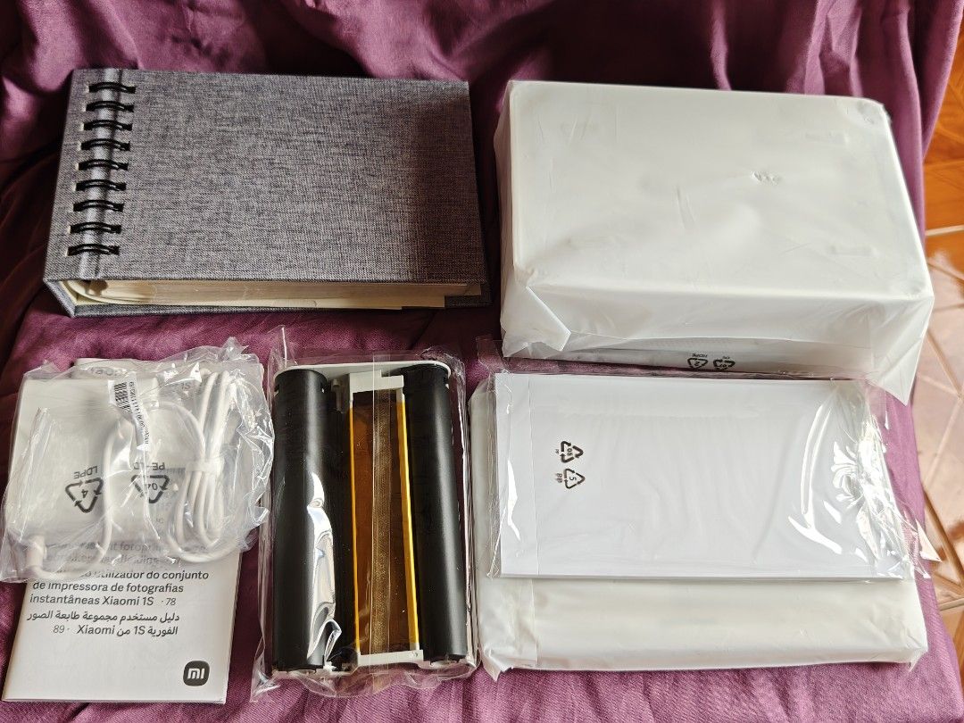 Xiaomi Instant Photo Printer 1S Set (Category: Printers, Scanners & Copiers) located in Quezon City. Submitted by farsiren06 (Listing ID 1424497362, Image 2). Description: Xiaomi Instant Photo Printer 1S Set. It includes the printer, photo paper, and a photo album with 50 pages. Also included are a charging cable and other accessories. The printer is white and comes with a gray photo album. -Open box na po sya kasi chineck ko lang po yung laman. 