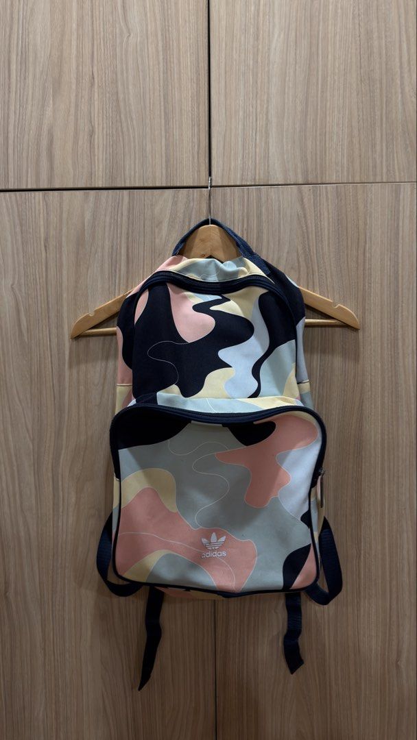 Adidas Camo Backpack (Category: Backpacks) located in Alfonso. Submitted by jbcamet (Listing ID 1429318271, Image 1). Description: Adidas backpack with a colorful camo pattern. Features a main compartment, a front pocket, and adjustable straps. The interior has a dark blue lining with an Adidas tag. The zipper has an Adidas logo. Perfect for everyday use or travel..
