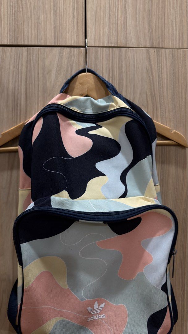 Adidas Camo Backpack (Category: Backpacks) located in Alfonso. Submitted by jbcamet (Listing ID 1429318271, Image 3). Description: Adidas backpack with a colorful camo pattern. Features a main compartment, a front pocket, and adjustable straps. The interior has a dark blue lining with an Adidas tag. The zipper has an Adidas logo. Perfect for everyday use or travel..