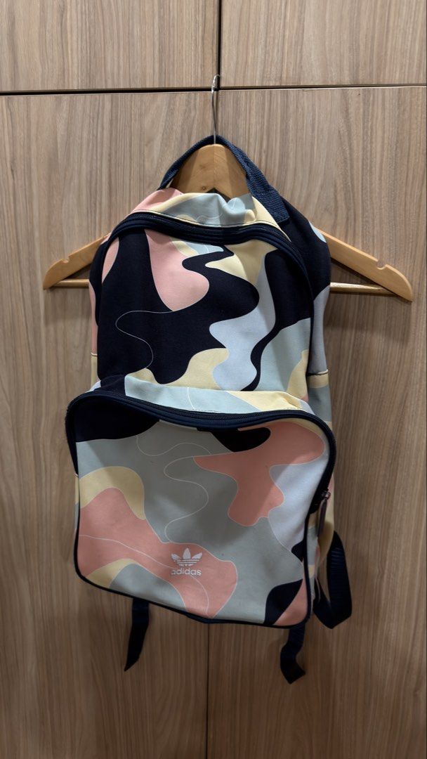 Adidas Camo Backpack (Category: Backpacks) located in Alfonso. Submitted by jbcamet (Listing ID 1429318271, Image 2). Description: Adidas backpack with a colorful camo pattern. Features a main compartment, a front pocket, and adjustable straps. The interior has a dark blue lining with an Adidas tag. The zipper has an Adidas logo. Perfect for everyday use or travel..