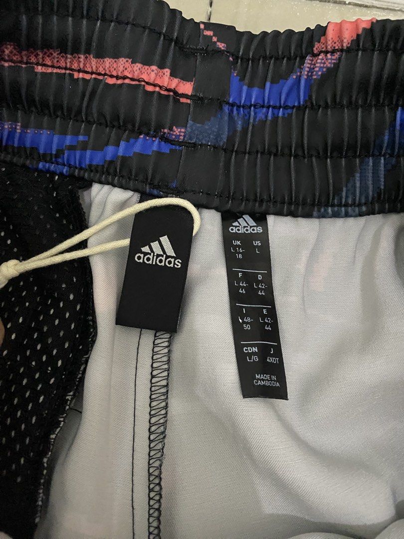 Adidas Printed Shorts - Size L (Category: Shorts) located in Rizal. Submitted by decluttermommaa (Listing ID 1429220084, Image 2). Description: Adidas shorts with a unique printed design. Features the Adidas logo and the iconic three stripes. The shorts have an elastic waistband with a drawstring. Size L. Made in Cambodia. The shorts have a mesh lining..
