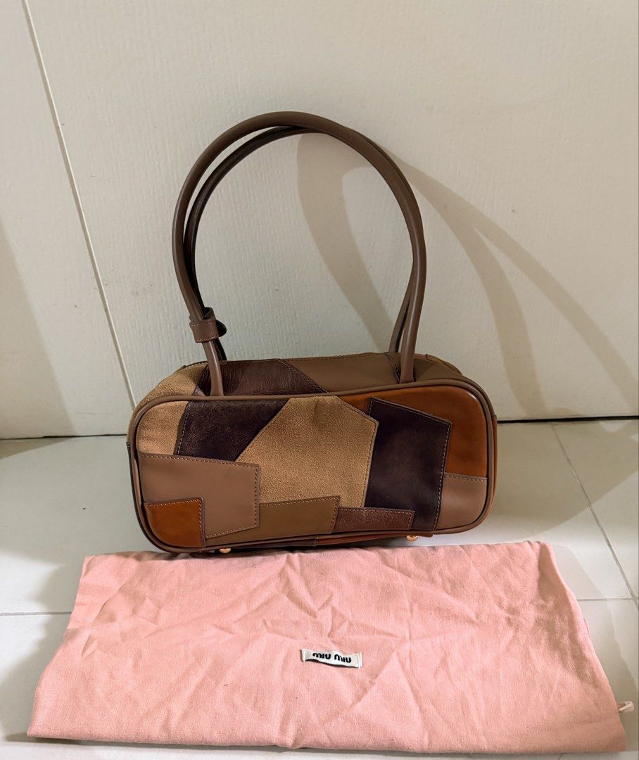 Guaranteed Original Miu Miu beau Patchwork top handle bag (Category: Luxury Bags & Wallets) located in Manila. Submitted by declutterdiva25 (Listing ID 1429186184, Image 3). Description: Authentic Miu Miu handbag featuring a patchwork design in various shades of brown. It has a top zipper closure and dual top handles. The interior includes a Miu Miu logo and a small tag with the number 197. Comes with a dust bag. Guaranteed original Fits pro max,