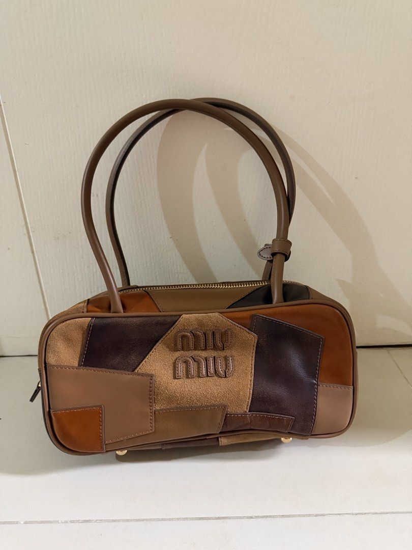 Guaranteed Original Miu Miu beau Patchwork top handle bag (Category: Luxury Bags & Wallets) located in Manila. Submitted by declutterdiva25 (Listing ID 1429186184, Image 1). Description: Authentic Miu Miu handbag featuring a patchwork design in various shades of brown. It has a top zipper closure and dual top handles. The interior includes a Miu Miu logo and a small tag with the number 197. Comes with a dust bag. Guaranteed original Fits pro max,