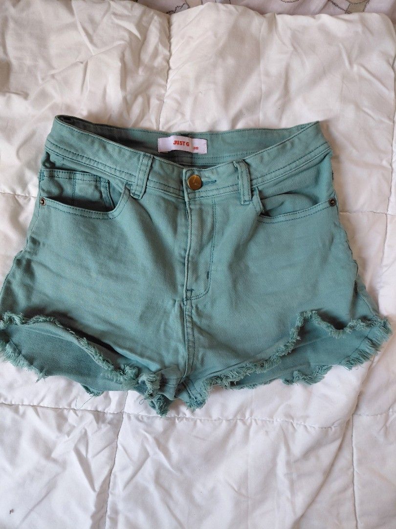 Just G Green Denim Shorts (Category: Shorts) located in Cainta. Submitted by chickennuggirl (Listing ID 1429202778, Image 1). Description: Stylish green denim shorts. Features a button closure and a frayed hem design. Perfect for casual wear. The shorts have pockets and belt loops. The label is visible, but the brand is unreadable. A versatile addition to any wardrobe..