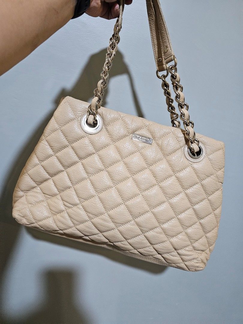 Kate Spade Quilted Shoulder Bag (Category: Luxury Bags & Wallets) located in Cagayan de Oro. Submitted by hotpink26 (Listing ID 1429178365, Image 3). Description: Kate Spade handbag features a quilted design with chain straps. It has a beige exterior and a zippered interior pocket. The bag has a rectangular shape and a metal Kate Spade tag..