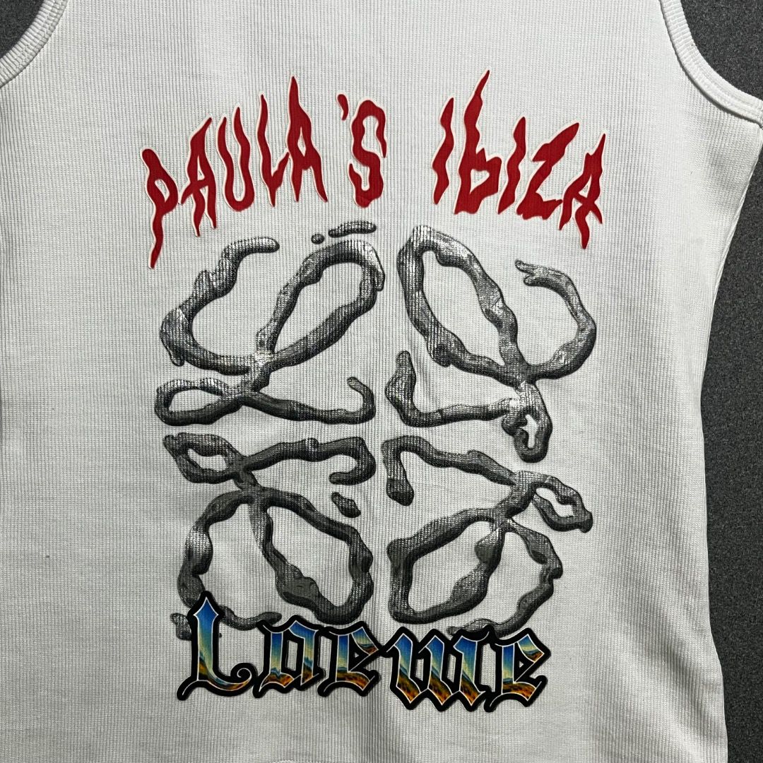 Loewe Paula's Ibiza Tank Top (Category: Luxury Apparel) located in Bacolod City. Submitted by boujee.wardrobes (Listing ID 1429319254, Image 3). Description: White tank top from Loewe Paula's Ibiza collection. Features a graphic print on the front and the Loewe logo. Made in Portugal. Size M. Made of 95% cotton and 5% elastane. The tank top has a ribbed texture. 21L 14W.