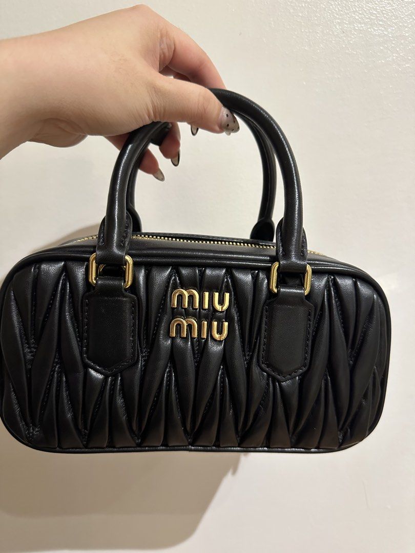 Miu Miu Matelassé Arcadie (Category: Luxury Bags & Wallets) located in Binan City. Submitted by ladylacy24 (Listing ID 1429292043, Image 1). Description: Mini bowling bag features a quilted design and a top zip closure. It has two top handles and gold-tone hardware. The Miu Miu logo is prominently displayed on the front. The zipper pulls also have the Miu Miu logo. well loved.