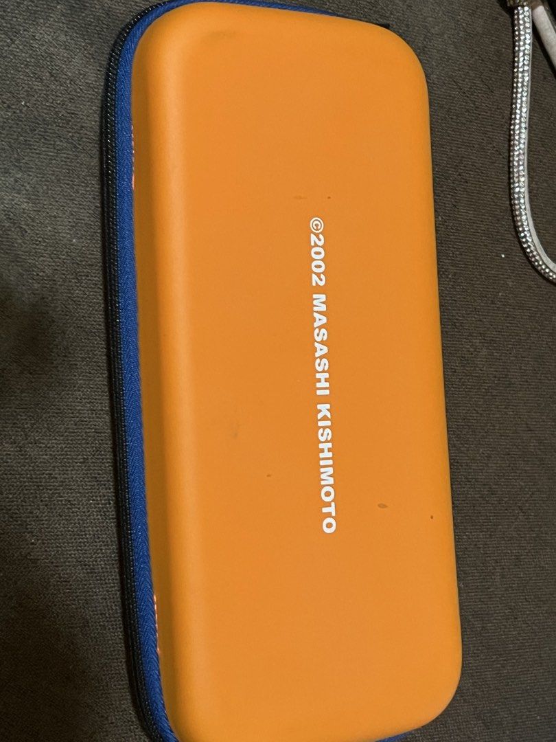 Naruto Nintendo Switch Carrying Case (Category: Cases & Covers) located in Taguig. Submitted by random.stuff31 (Listing ID 1429217503, Image 2). Description: Selling this Naruto-themed carrying case for Nintendo Switch. Features the iconic Hidden Leaf Village symbol and “©2002 Masashi Kishimoto” print—perfect for anime fans! Sturdy outer shell helps protect your Switch from scratches, bumps, and dust. Compact and travel-friendly with zipper closu