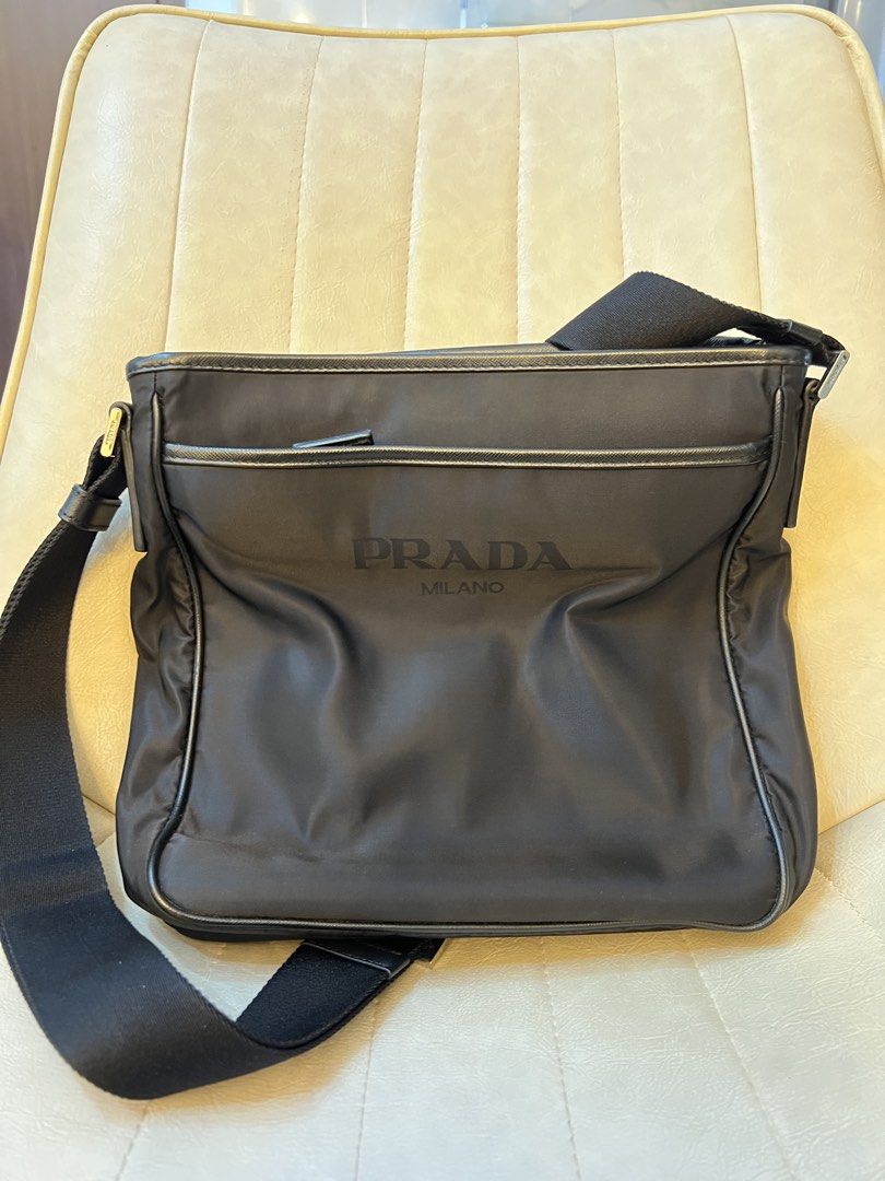 Prada Messenger Bag (Category: Luxury Bags & Wallets) located in Mandaluyong City. Submitted by ilovenicethings888 (Listing ID 1429287036, Image 3). Description: Black Prada messenger bag. Features a front flap with the Prada logo and a shoulder strap with the Prada logo. The bag has multiple compartments, including a main compartment and a front pocket. The interior has a Prada logo tag..