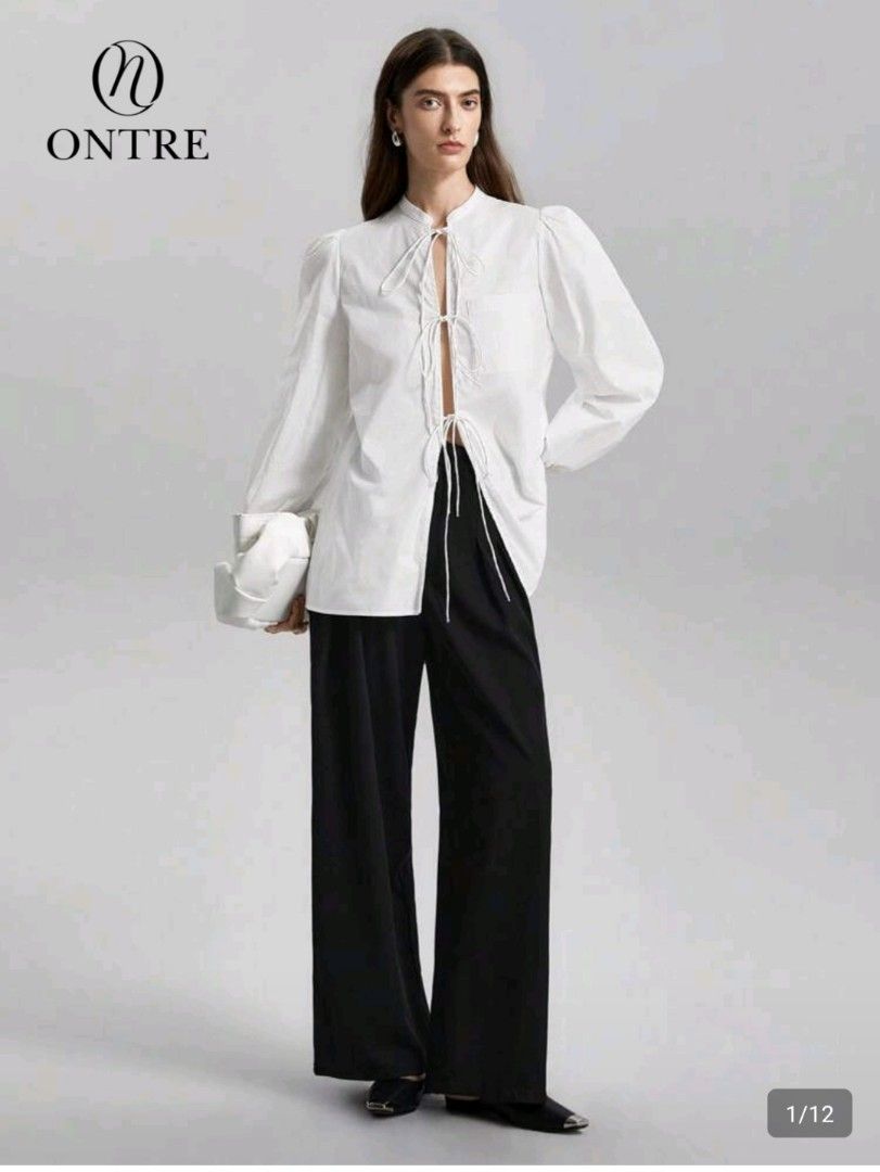 SHEIN Blouse with Tie Front (Category: Blouses) located in Las Pinas. Submitted by mgr29 (Listing ID 1429176706, Image 1). Description: LOOSE CAN FIT SMALL - SEMI LARGE White blouse from SHEIN with a tie-front design. Features long sleeves with puff shoulders. The blouse has a mandarin collar and a relaxed fit. The tag is still attached. Perfect for a casual yet stylish look..