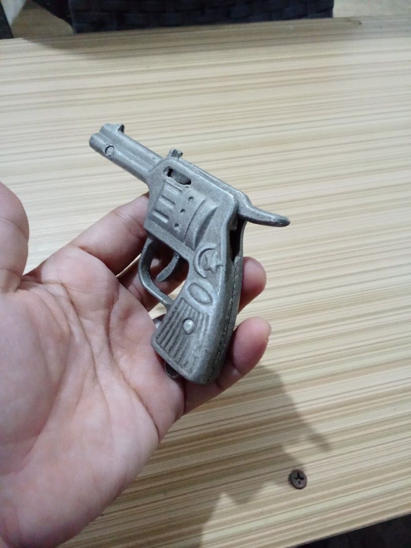 Vintage Metal Toy Gun (Category: Action & Battle Toys) located in Bocaue. Submitted by marajapansurplus (Listing ID 1429293690, Image 2). Description: Vintage metal toy gun. It has a revolver design with intricate details. The gun features a trigger, hammer, and cylinder. It has an "SK" marking on the side. It is a collectible item..