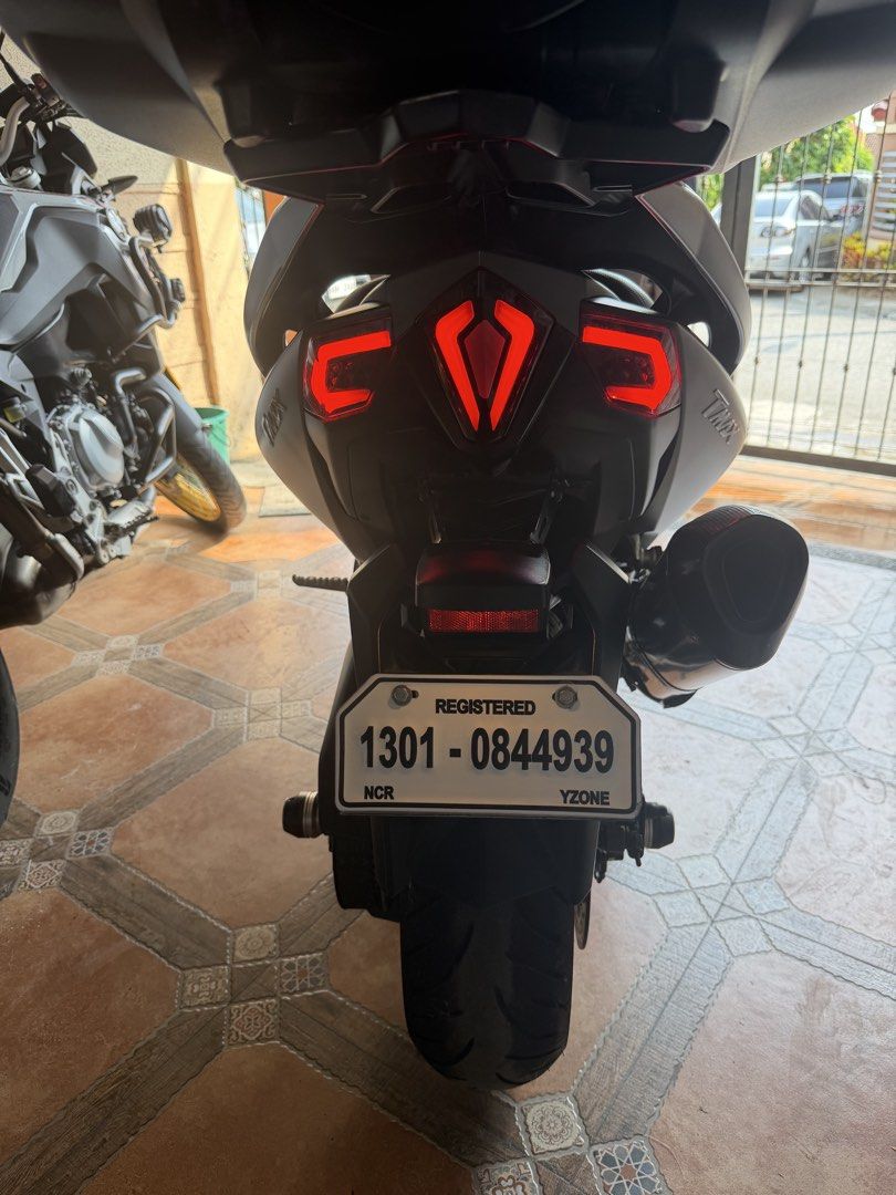 Yamaha TMAX 530 (Category: Motorbikes for Sale) located in Manila. Submitted by sandy03tol59753 (Listing ID 1429299151, Image 1). Description: Yamaha TMAX 560 motorcycle. Features a black top box, gold rims, and a custom exhaust. The motorcycle has a grey body with a tinted windscreen. The license plate number is 1301-0844939. Includes a passenger seat and a sleek design..