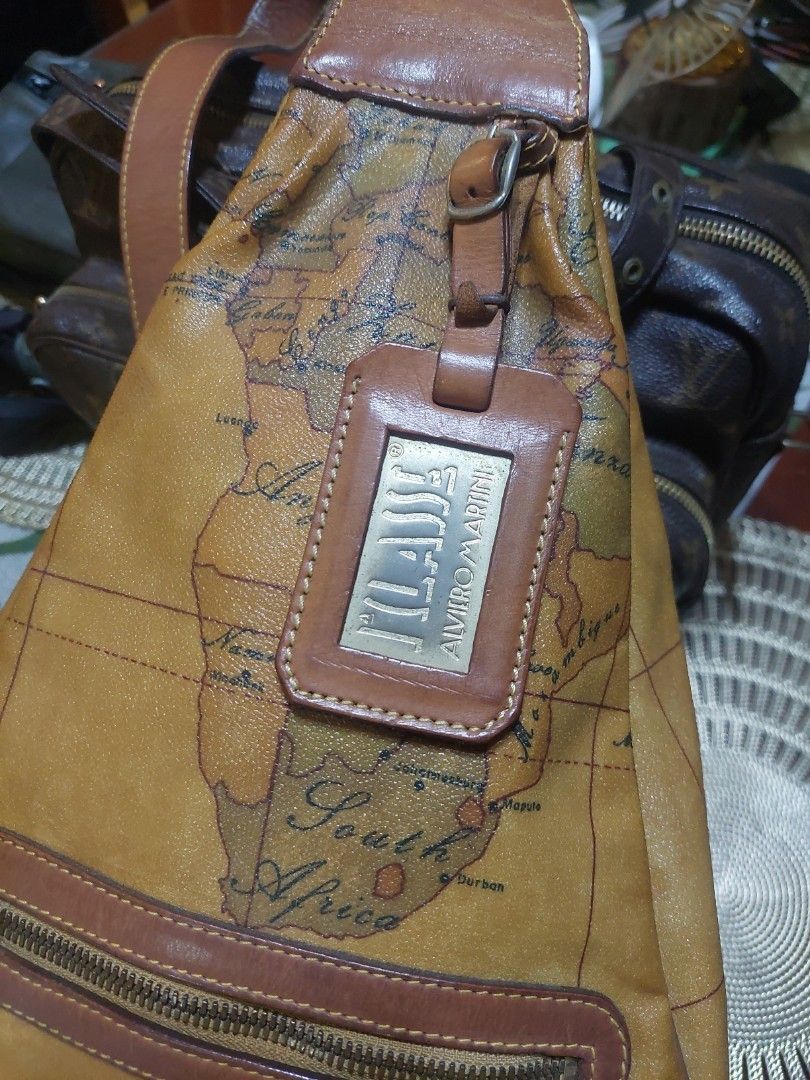 Alviero Martini Geo Map Sling Bag (Category: Luxury Bags & Wallets) located in Puerto Princesa. Submitted by YeSurJOMS (Listing ID 1429354457, Image 2). Description: Authentic Alviero Martini sling bag featuring a distinctive geo map design. It has a brown leather strap and trim, with a zipper closure. The bag includes a luggage tag holder and a branded zipper pull. The interior has a branded tag. A stylish and functional accessory for everyday u