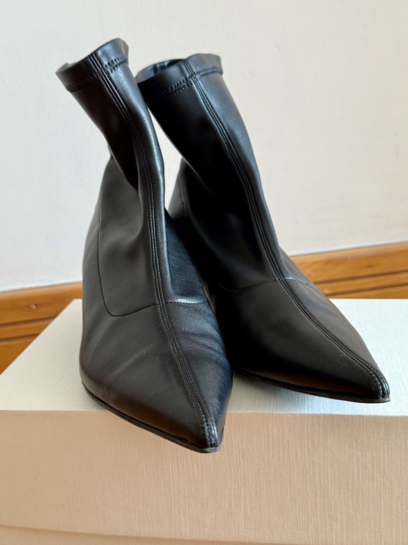 Anine Bing Black Leather Boots （分類：靴）位於 Hong Kong。 由 moglom 提交（商品編號 1429360395，圖片 2）。簡介： Black leather ankle boots by Anine Bing. Features a pointed toe and a kitten heel. The boots have a sock-like upper and a small gold logo detail on the heel. The soles are black and show some wear. Size 38.。
