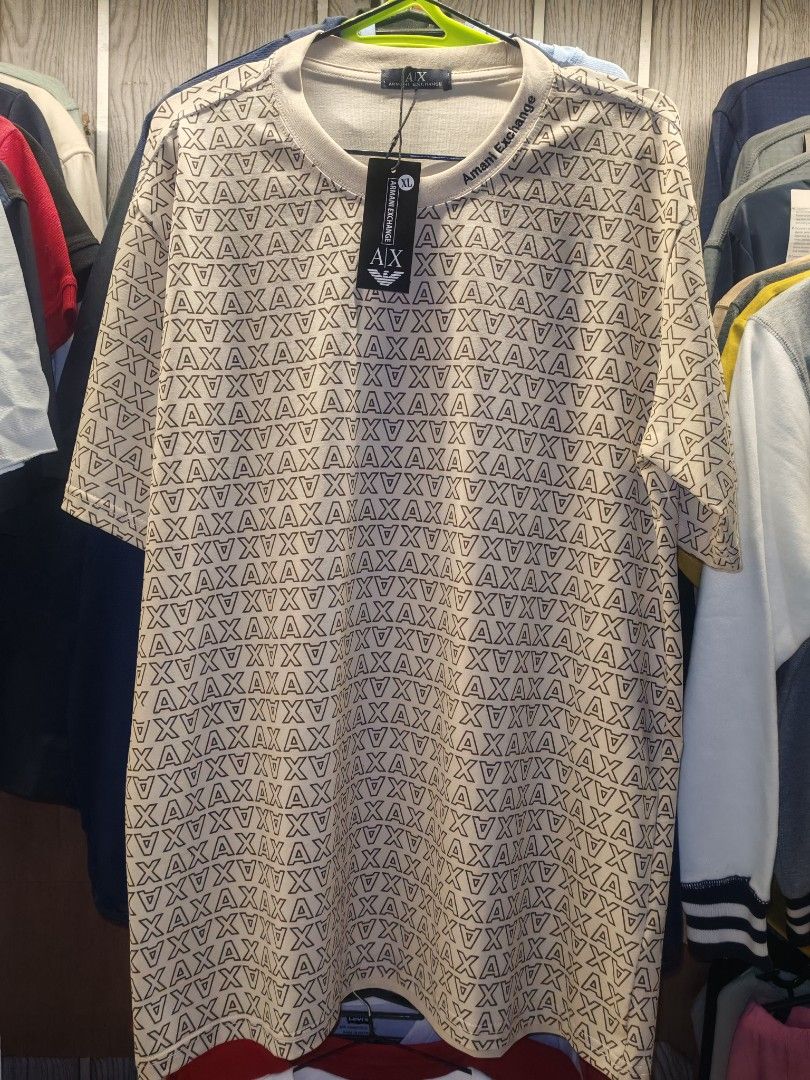 Armani Exchange AX T-Shirt (Category: Tshirts & Polo Shirts ) located in Quezon City. Submitted by rowem (Listing ID 1429479365, Image 3). Description: Armani Exchange AX T-shirts available in black beige, white and gray. Features an all-over AX logo pattern. Comes with original tags. The beige shirt has "Armani Exchange" printed on the neckline. Short-sleeved and likely made of a comfortable fabric. Sizes Available XL/XXL/XXXL.