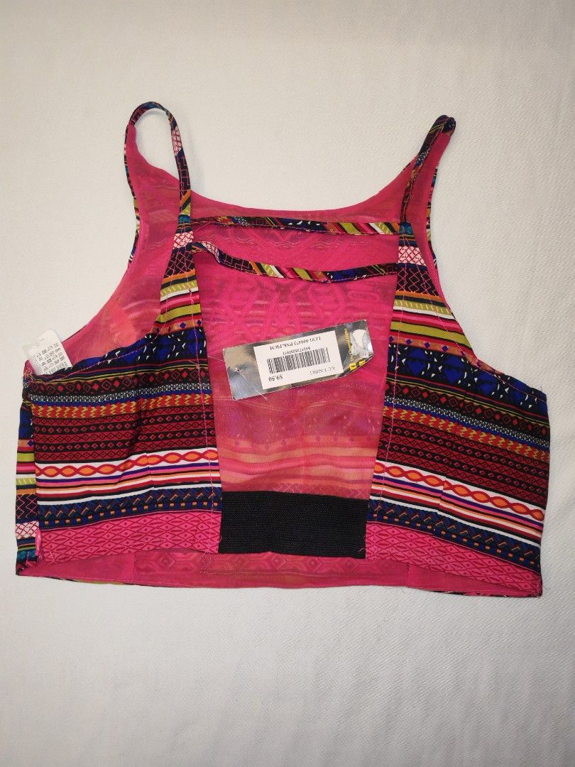 Bershka Embroidered Crop Top (Category: Others Tops) located in Quezon City. Submitted by rowem (Listing ID 1429474443, Image 2). Description: Bershka crop top features a vibrant, patterned design with a pink embroidered detail on the front. It has a halter neck style with thin straps and a unique back design. The top includes a black band at the bottom. The tags are still attached..
