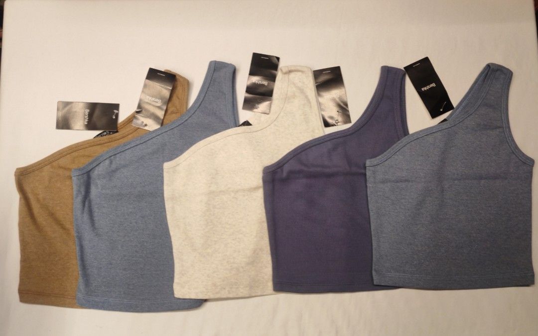 Bershka One Shoulder Top (Category: Sleeveless) located in Quezon City. Submitted by rowem (Listing ID 1429464690, Image 1). Description: Original Bershka Made in Vietnam, A Stylish one-shoulder top from Bershka. Available in three colors: brown, beige, and blue. Features a ribbed texture. Perfect for a casual yet chic look. Made in Vietnam. The tag is still attached. Sizes S/M/L.