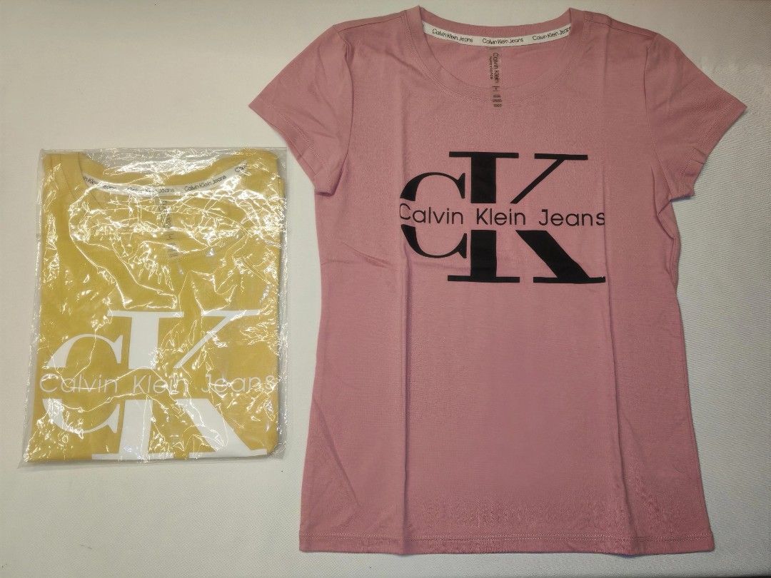 Calvin Klein Jeans T-shirts (Category: Shirts) located in Quezon City. Submitted by rowem (Listing ID 1429476473, Image 2). Description: These Calvin Klein Jeans t-shirts are available in yellow and pink. They feature the Calvin Klein Jeans logo on the front. The t-shirts appear to be unworn and are still in their original packaging. They have a classic crew neck design..