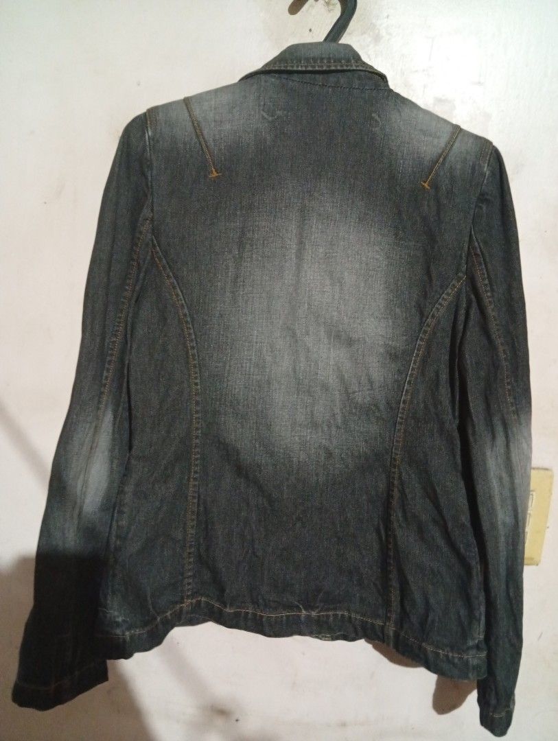 Chevignon Denim Jacket - Medium (Category: Coats, Jackets and Outerwear) located in Las Pinas. Submitted by magda09 (Listing ID 1429421491, Image 2). Description: Stylish denim jacket from Chevignon. Features a classic design with button closure and two front pockets. The jacket has a medium size. The back of the jacket has a tailored design. The jacket is a dark denim color. The brand name is embroidered on the collar..