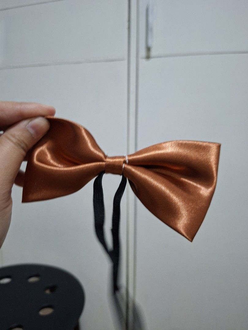 Copper Satin Bow Tie (Category: Ties) located in Paranaque City. Submitted by potatoiceblended (Listing ID 1429413136, Image 1). Description: Elegant copper-colored satin bow tie. Features a classic bow shape with a black adjustable strap. Perfect for formal events or adding a touch of sophistication to any outfit. The bow tie is made of a shiny satin material..