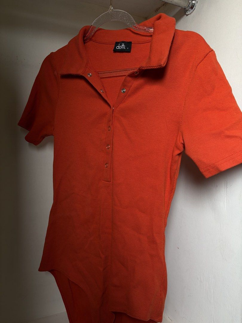 Dotti Orange Ribbed Bodysuit (Category: Sleeveless) located in Pulilan. Submitted by margaretsedit (Listing ID 1429416448, Image 1). Description: Orange ribbed bodysuit from Dotti. Features a collared neckline and short sleeves. It has snap closures at the front and bottom. The size is M. Add 62 for SF.