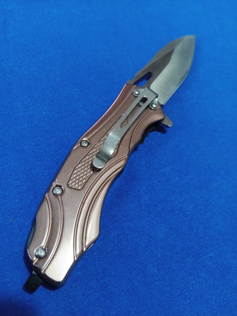 E.D.C - 03 (Category: Hiking & Camping) located in Bulacan. Submitted by Sina_Unang_Yaman (Listing ID 1429504129, Image 2). Description: Browning folding knife features a stainless steel blade and a bronze-colored handle. The knife includes a pocket clip for easy carrying. The box is included. The blade has the Browning logo. The handle has a textured grip for secure handling..