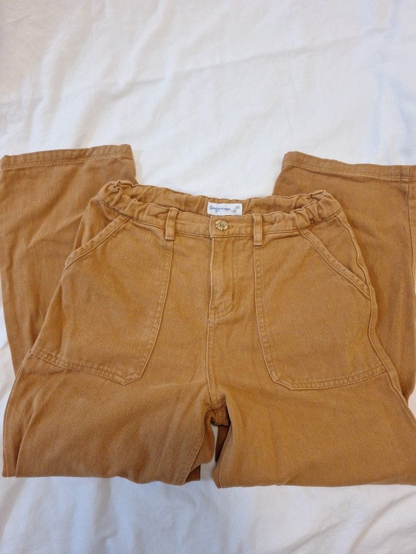 Gingersnaps Boys Pants (Category: Babies & Kids Fashion) located in Antipolo. Submitted by flutterby41319 (Listing ID 1429372712, Image 2). Description: These pants from Gingersnaps Boys feature a button closure and two front pockets. The pants have an elastic waistband and a straight leg design. The color is a warm brown. The brand tag is visible on the side. These pants are suitable for everyday wear. Size 10 .