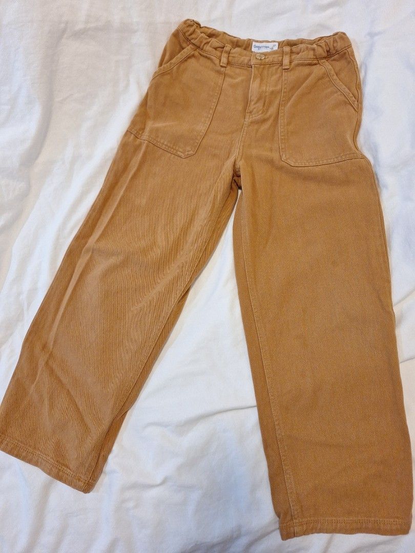Gingersnaps Boys Pants (Category: Babies & Kids Fashion) located in Antipolo. Submitted by flutterby41319 (Listing ID 1429372712, Image 3). Description: These pants from Gingersnaps Boys feature a button closure and two front pockets. The pants have an elastic waistband and a straight leg design. The color is a warm brown. The brand tag is visible on the side. These pants are suitable for everyday wear. Size 10 .