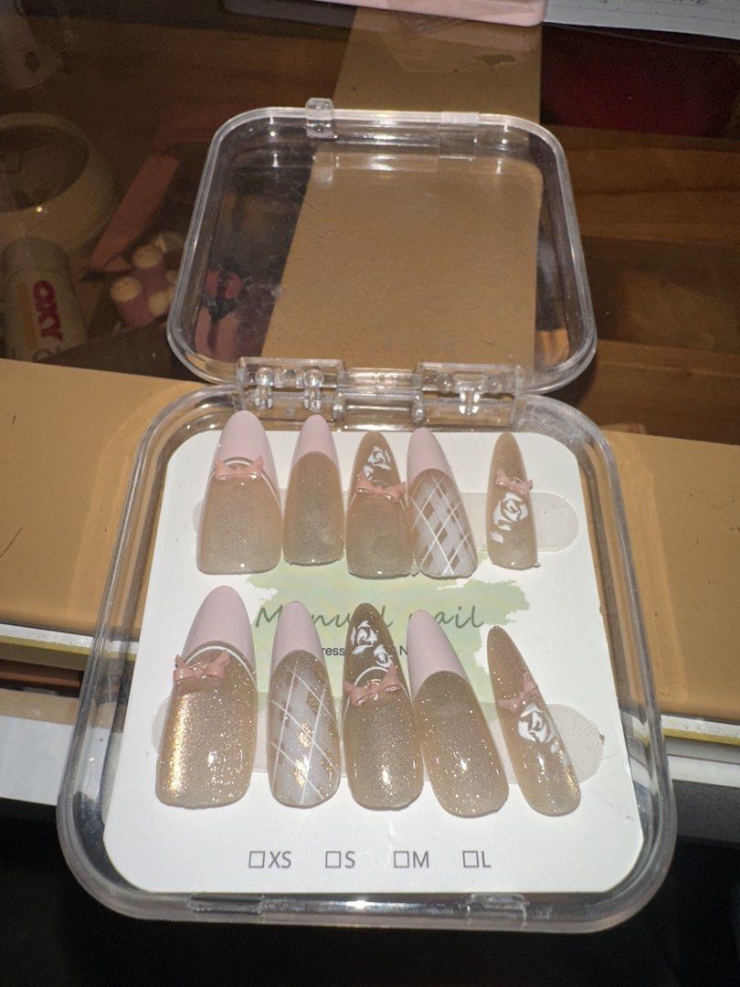 Manual Nail Press On Set - New (Category: Hands & Nails) located in Singapore. Submitted by xuannis_beauty (Listing ID 1429435094, Image 1). Description: Brand new press-on nail set. Features a glittery nude base with pink tips and cute bow accents. Includes various sizes for a perfect fit. Easy to apply and ready to wear. Get salon-quality nails at home!.