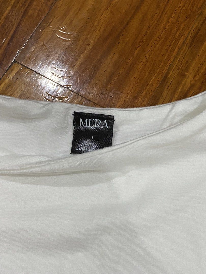 Mera White T-shirt - Size L (Category: Shirts) located in Quezon City. Submitted by closetpg (Listing ID 1429471057, Image 2). Description: White Mera T-shirt. Features a crew neck and short sleeves. The tag indicates a size L. Made of a smooth, likely lightweight fabric. A simple, versatile top suitable for various casual outfits. Good quality, soft and contouring fabric..