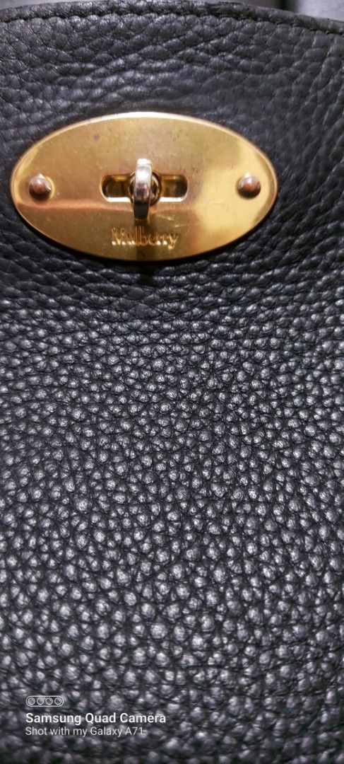 Mulberry Black Leather Tote Bag (Category: Luxury Bags & Wallets) located in Quezon City. Submitted by threetwotwo2ndaccount (Listing ID 1429503463, Image 2). Description: Black leather tote bag with a gold-tone clasp. Features a brown interior with a small pocket. The bag is marked "Made in England". The leather has a pebbled texture. The bag has two handles. There is a small tag with an "X" on it. size: H-13",L-17.5",W-5" issue: may minimal fla