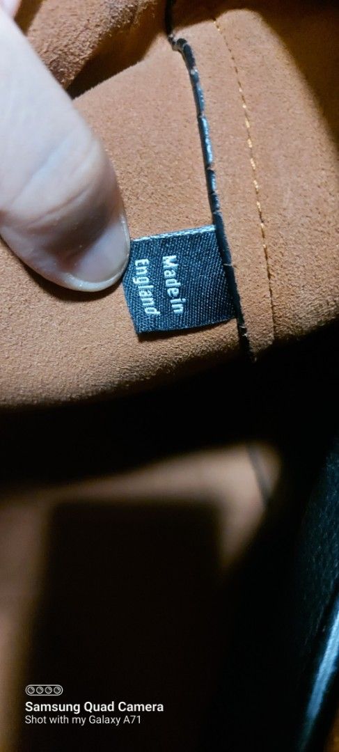 Mulberry Black Leather Tote Bag (Category: Luxury Bags & Wallets) located in Quezon City. Submitted by threetwotwo2ndaccount (Listing ID 1429503463, Image 3). Description: Black leather tote bag with a gold-tone clasp. Features a brown interior with a small pocket. The bag is marked "Made in England". The leather has a pebbled texture. The bag has two handles. There is a small tag with an "X" on it. size: H-13",L-17.5",W-5" issue: may minimal fla