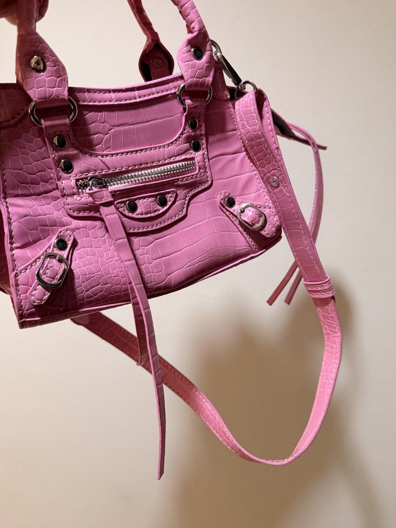 Pink Crocodile-Embossed Handbag (Category: Luxury Bags & Wallets) located in Taguig. Submitted by luxeria_ (Listing ID 1429361131, Image 3). Description: -Pink handbag - features a crocodile-embossed design. -It has a top handle and a detachable shoulder strap. -The bag has a zippered main compartment and a small pocket on the side. -The interior is black. -It has silver-tone hardware and decorative studs. -Balen Inspired only -negotiable.