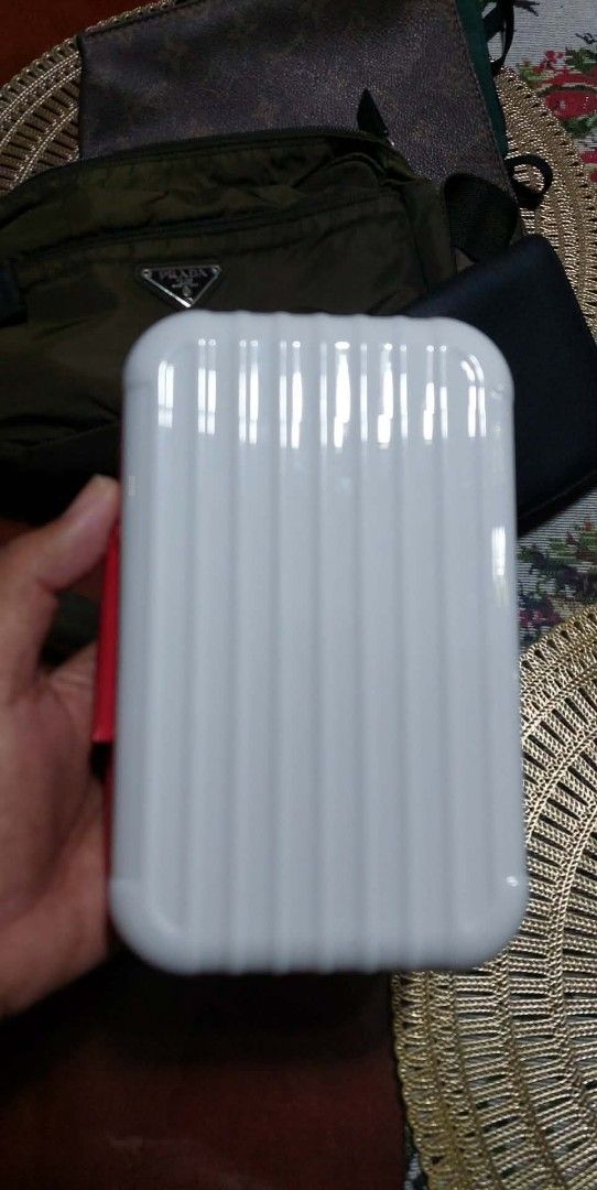 Porsche Rimowa (Category: Luxury Bags & Wallets) located in Puerto Princesa. Submitted by YeSurJOMS (Listing ID 1429364798, Image 2). Description: White Porsche Design pencil case with a red zipper and trim. Features the Porsche logo on the front. The interior is black. The case has a rectangular shape with a ridged design on the front and back. The zipper has the Porsche Design logo..