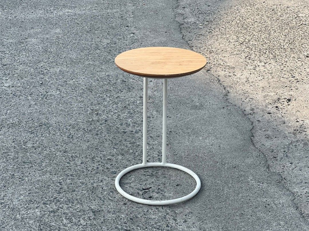 Round Side Table with White Frame (Category: Tables & Sets) located in Valenzuela. Submitted by upcycle_things (Listing ID 1429441103, Image 1). Description: Side table features a round wooden top and a white metal frame. The frame has a circular base for stability and two vertical supports. It's a simple yet stylish piece, perfect for small spaces or as an accent table. The table is ideal for holding drinks, books, or decorative items..