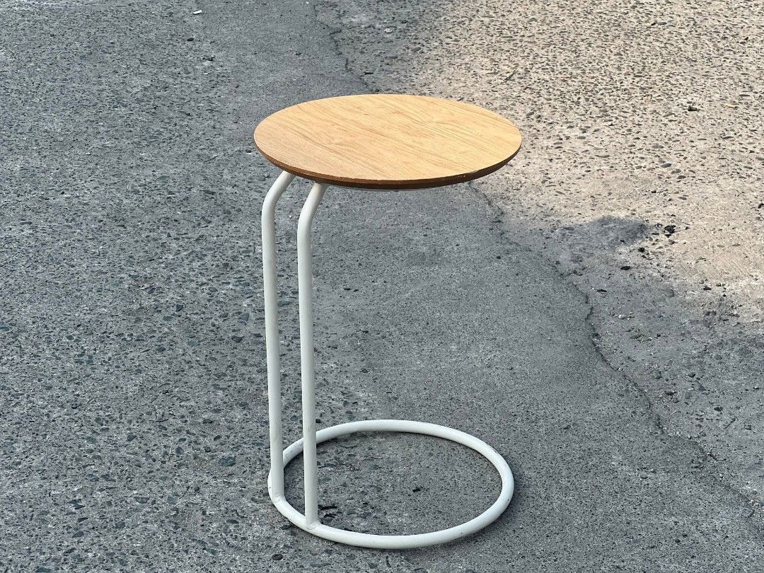 Round Side Table with White Frame (Category: Tables & Sets) located in Valenzuela. Submitted by upcycle_things (Listing ID 1429441103, Image 2). Description: Side table features a round wooden top and a white metal frame. The frame has a circular base for stability and two vertical supports. It's a simple yet stylish piece, perfect for small spaces or as an accent table. The table is ideal for holding drinks, books, or decorative items..