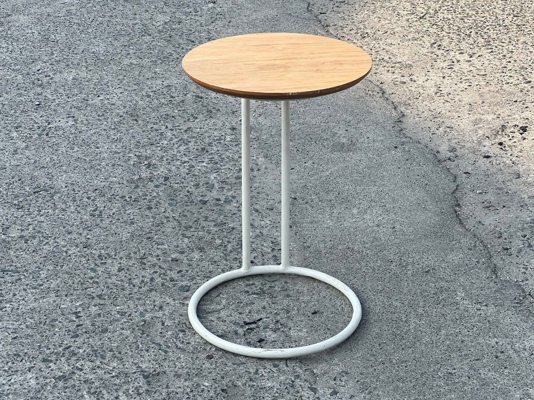 Round Side Table with White Frame (Category: Tables & Sets) located in Valenzuela. Submitted by upcycle_things (Listing ID 1429441103, Image 3). Description: Side table features a round wooden top and a white metal frame. The frame has a circular base for stability and two vertical supports. It's a simple yet stylish piece, perfect for small spaces or as an accent table. The table is ideal for holding drinks, books, or decorative items..