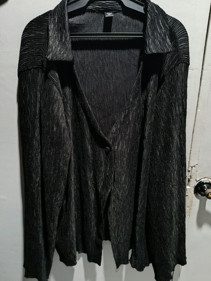 Shein Curve Pleated Blouse 4XL (Category: Blouses) located in Subic. Submitted by yssacollection (Listing ID 1429494729, Image 1). Description: Black pleated blouse from Shein Curve. It has a collared neckline and long sleeves. The blouse has a single button closure. The size is 4XL. The fabric has a textured, pleated design. The blouse is hanging on a black hanger..
