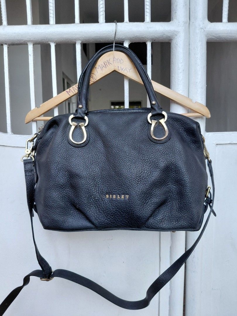 Sisley Black Handbag with Gold Hardware (Category: Luxury Bags & Wallets) located in Cabuyao City. Submitted by markrodbal45397 (Listing ID 1429414632, Image 1). Description: Black Sisley handbag with gold-colored hardware. Features a top handle and a detachable shoulder strap. The interior has multiple compartments and a zipper closure. The bag has a textured exterior and a gold Sisley logo. Includes a small front zipper pocket. Made in China..