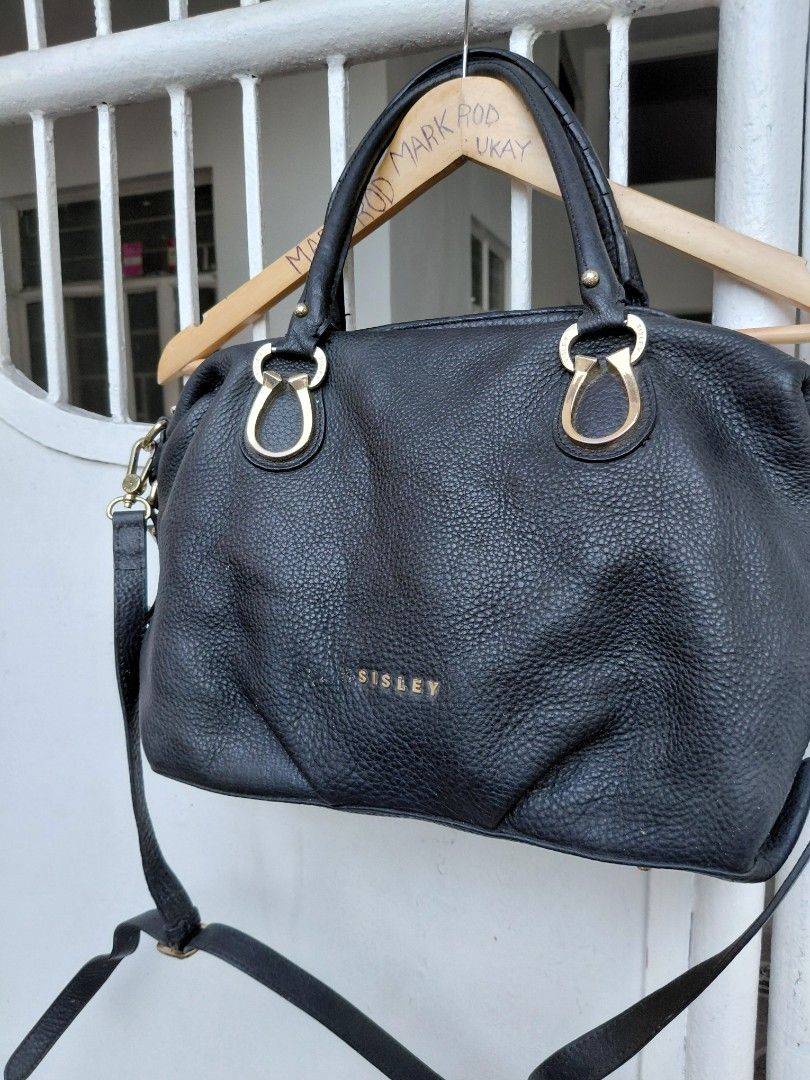 Sisley Black Handbag with Gold Hardware (Category: Luxury Bags & Wallets) located in Cabuyao City. Submitted by markrodbal45397 (Listing ID 1429414632, Image 2). Description: Black Sisley handbag with gold-colored hardware. Features a top handle and a detachable shoulder strap. The interior has multiple compartments and a zipper closure. The bag has a textured exterior and a gold Sisley logo. Includes a small front zipper pocket. Made in China..