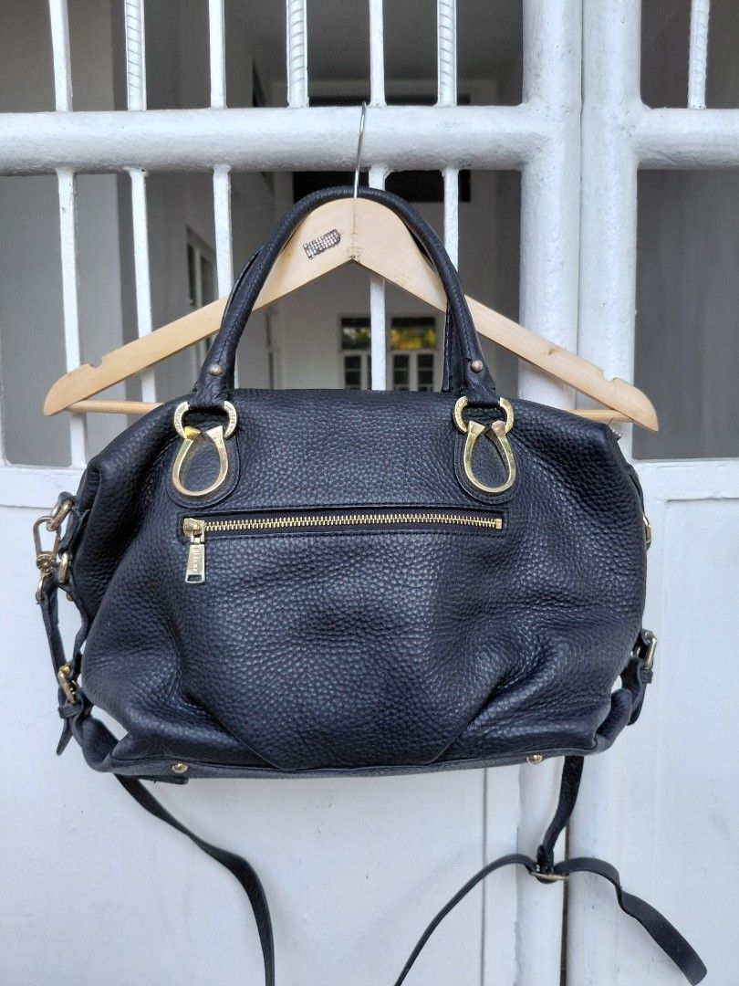 Sisley Black Handbag with Gold Hardware (Category: Luxury Bags & Wallets) located in Cabuyao City. Submitted by markrodbal45397 (Listing ID 1429414632, Image 3). Description: Black Sisley handbag with gold-colored hardware. Features a top handle and a detachable shoulder strap. The interior has multiple compartments and a zipper closure. The bag has a textured exterior and a gold Sisley logo. Includes a small front zipper pocket. Made in China..