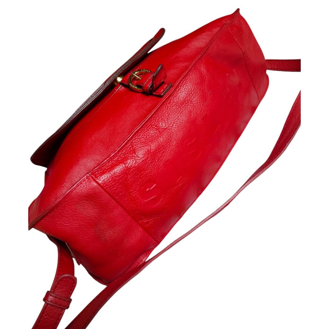 Sisley Red Leather Handbag (Category: Luxury Bags & Wallets) located in Bacolod City. Submitted by maejuntado33 (Listing ID 1429400923, Image 3). Description: Red leather handbag from Sisley features a top handle and a detachable shoulder strap. It has a flap closure with a buckle and gold-tone hardware. The bag has a zip closure and a logo detail on the front..