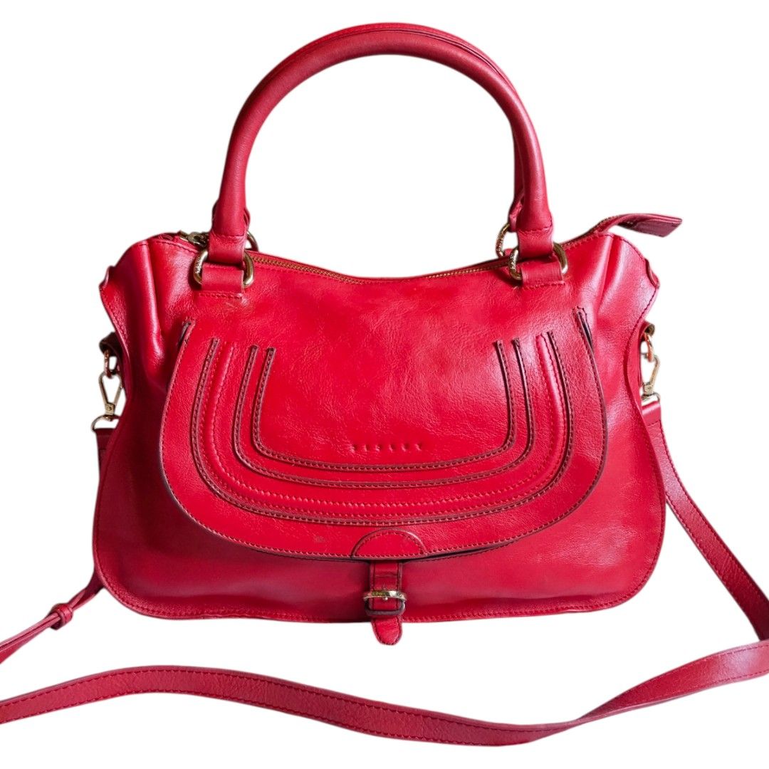 Sisley Red Leather Handbag (Category: Luxury Bags & Wallets) located in Bacolod City. Submitted by maejuntado33 (Listing ID 1429400923, Image 1). Description: Red leather handbag from Sisley features a top handle and a detachable shoulder strap. It has a flap closure with a buckle and gold-tone hardware. The bag has a zip closure and a logo detail on the front..