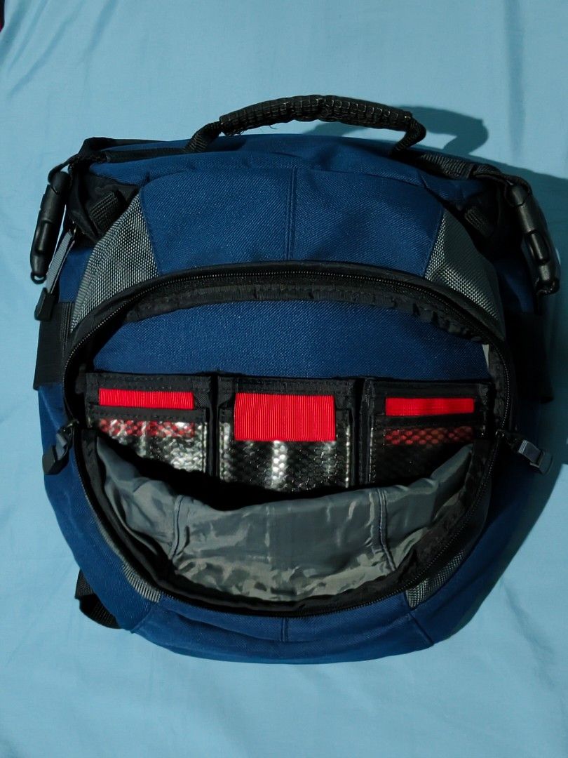 Tamrac Camera Bag (Velocity 8x) (Category: Cross-body Bags) located in Muntinlupa City. Submitted by sariromrom (Listing ID 1429491170, Image 2). Description: Tamrac camera bag is designed to protect your camera gear. It features a blue and gray color scheme with multiple compartments and adjustable dividers. The bag has a top handle, a shoulder strap, and a buckle closure. It also has a side pocket for accessories. The interior has padded divide