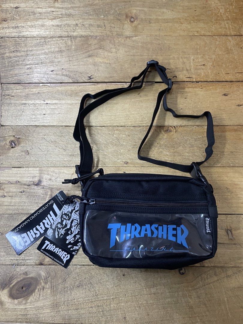 Thrasher Magazine Crossbody Bag (Category: Sling Bags) located in Manila. Submitted by vensen1798495 (Listing ID 1429485633, Image 1). Description: Black Thrasher crossbody bag. Features a clear front panel with the Thrasher logo in blue. Includes an adjustable strap and a zippered main compartment. The bag has a small Thrasher tag on the side and a tag with the brand's logo. Made in China. Brandnew no issues Dimes: 6Lx9W inches 650 pesos We ship