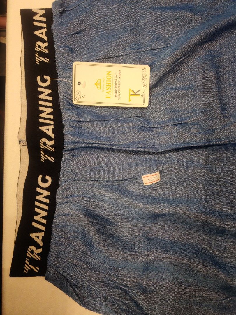 Training Pants with Elastic Waistband (Category: Other Bottoms) located in Quezon City. Submitted by rowem (Listing ID 1429471129, Image 2). Description: Blue training pants with an elastic waistband. The waistband features the word "TRAINING" printed repeatedly. The pants have a wide-leg design. A tag is attached to the pants..