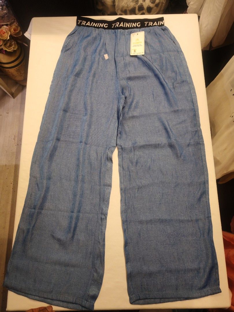 Training Pants with Elastic Waistband (Category: Other Bottoms) located in Quezon City. Submitted by rowem (Listing ID 1429471129, Image 1). Description: Blue training pants with an elastic waistband. The waistband features the word "TRAINING" printed repeatedly. The pants have a wide-leg design. A tag is attached to the pants..
