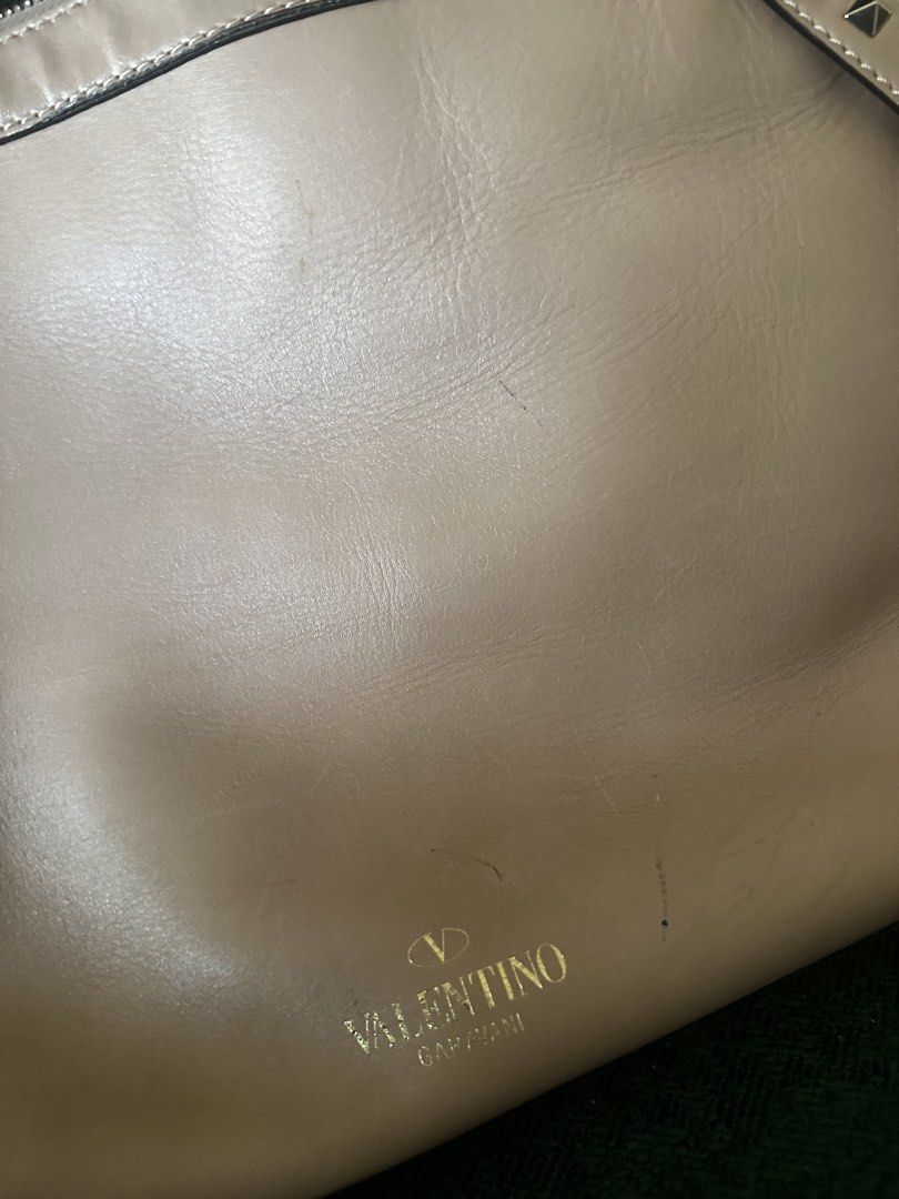 Valentino Garavani Rockstud Bag (Category: Luxury Bags & Wallets) located in Mandaluyong City. Submitted by hdvvv (Listing ID 1429342120, Image 2). Description: Authentic Valentino Garavani Rockstud shoulder tote. • Smooth beige/nude leather • Signature pyramid Rockstuds along the straps • Minimal logo Valentino Garavani” stamped at the front • Structured rectangular body with zip top Visible creases and light scratches - see photos. Complete stu