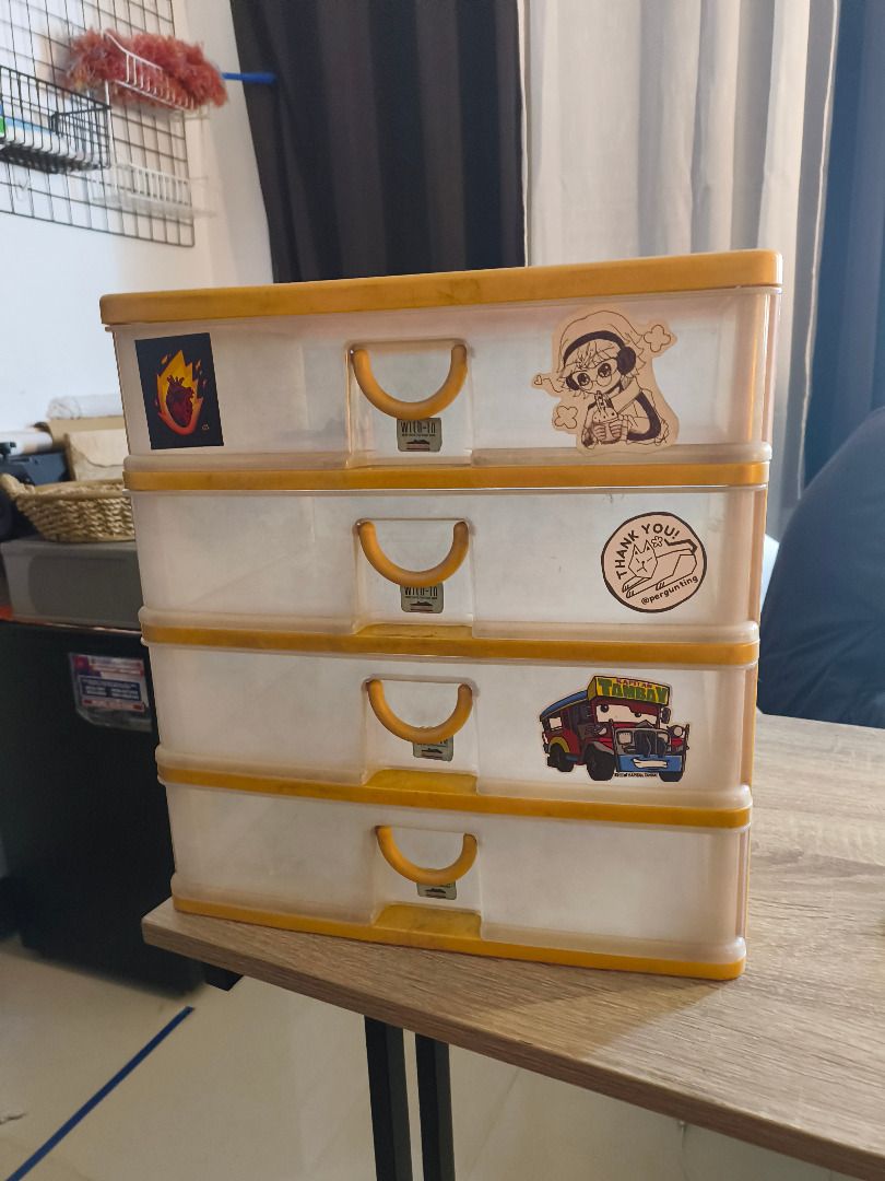 4-Tier Plastic Storage Box (Category: Storage Boxes & Baskets) located in Mandaluyong City. Submitted by delubyoboi (Listing ID 1424568667, Image 2). Description: 4-tier plastic storage box - Yellow frame and clear drawers -14 inches in height and 10 inches in width. Issues: - Signs of usage - Stickers RFS: Decluttering.