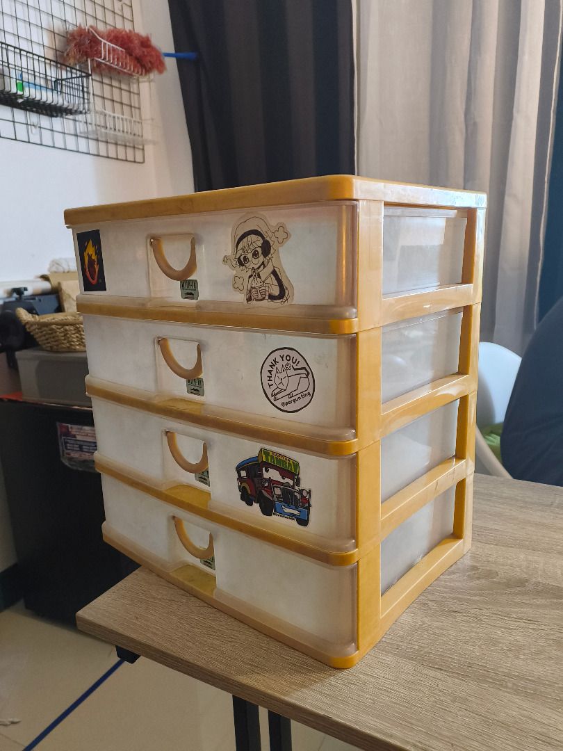 4-Tier Plastic Storage Box (Category: Storage Boxes & Baskets) located in Mandaluyong City. Submitted by delubyoboi (Listing ID 1424568667, Image 3). Description: 4-tier plastic storage box - Yellow frame and clear drawers -14 inches in height and 10 inches in width. Issues: - Signs of usage - Stickers RFS: Decluttering.